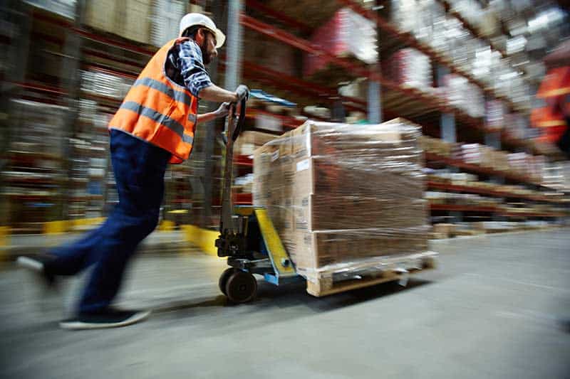 Logistics warehouse worker moving goods